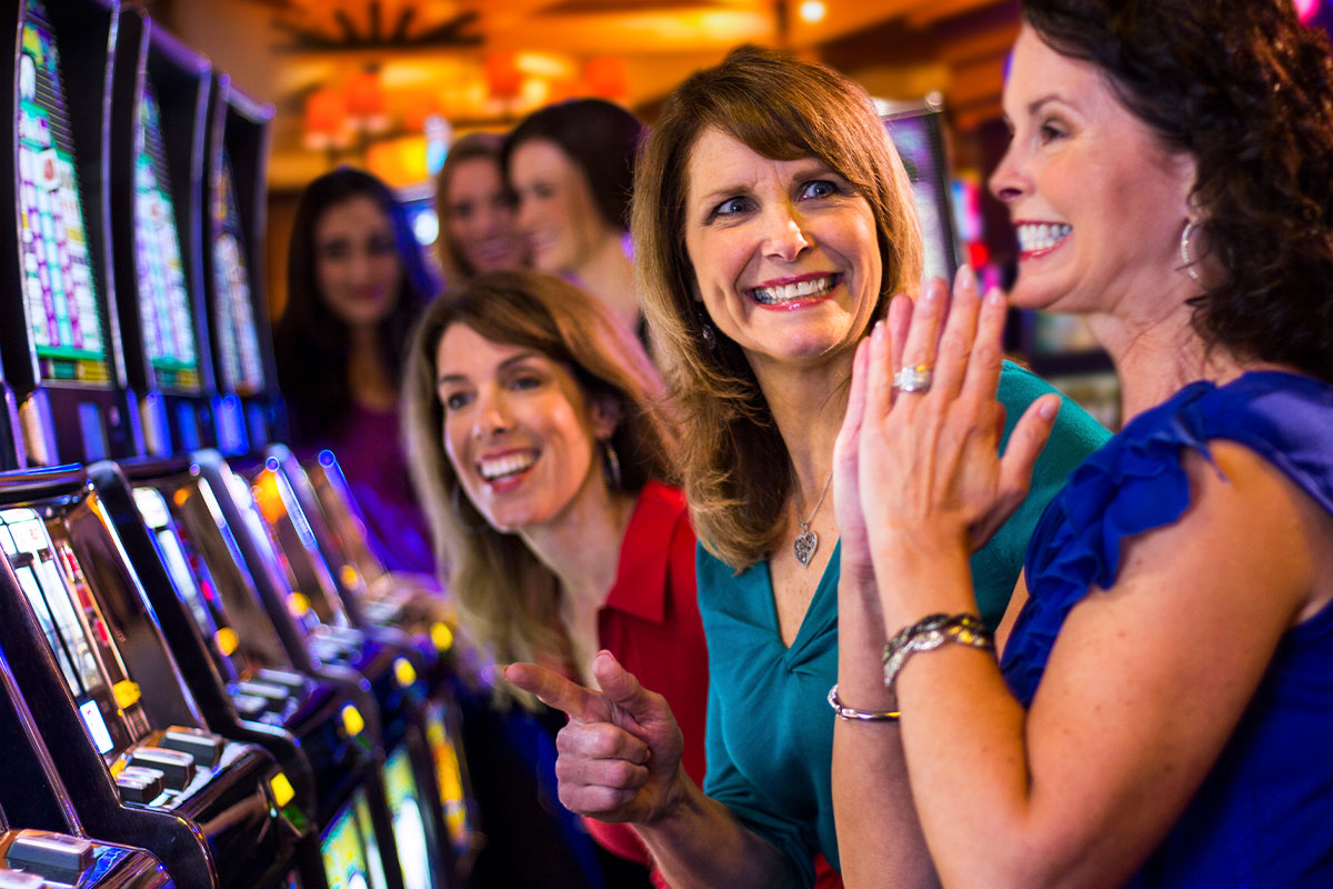 LADIES HAVING FUN AT SLOT MACHINE AT OXFORD CASINO HOTEL AND SPORTSBOOK
